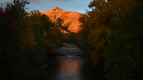 Der-Orangefarbene-Sonnenaufgang-Berührt-Die-Minenschule-Im-Herbst-Auf-Dem-Gipfel-Des-Aussichtsbergs,-Von-Der-Brücke-über-Den-Clear-Creek-Im-Goldenen-Colorado-Aus-Gesehen,-Statisch