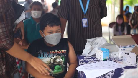 Yogyakarta,-Indonesien---20.-Dezember-2021:-Ein-Grundschuljunge-Bespricht-Mit-Einem-Arzt-Den-Erhalt-Eines-Covid19-Impfstoffs