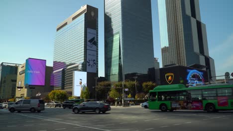 Centro-De-Comercio-Mundial-De-Seúl---Tráfico-De-Automóviles-Girando-En-El-Cruce-Que-Pasa-Por-La-Estación-De-Samseong-Cerca-De-La-Torre-Comercial-Coex-Y-La-Torre-Parnas-Y-El-Gran-Hotel-Intercontinental-Al-Atardecer-En-Otoño,-Corea