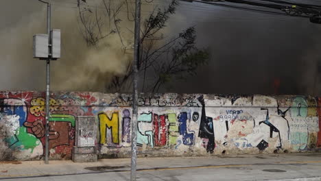 Quick-pan-right-through-smoky-urban-fire-scene-in-Sao-Paulo,-Brazil,-on-Tereza-Cristina-avenue,-Ipiranga-district