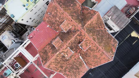 Aerial-overhead-orbit-shot-above-the-rooftop-of-little-chalet-house,-mueblería-diaz-at-9-de-Julio-avenue-in-downtown-Buenos-Aires-at-daytime