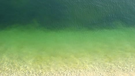 Close-up-of-a-drone-shot-over-green-smooth-water-surface
