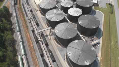 train-yard-silo-oil-gas-shipping-logistics-industry-aerial-drone-tilting-georgia-usa