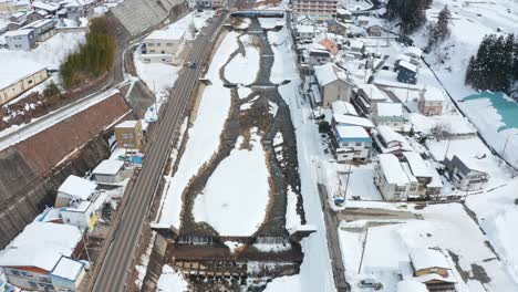 Yamanouchi-Onsen-Town,-Aerial-View-Tilt-Revealing-Snowy-Landscape,-Japan