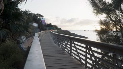 Eine-Eisenbahnbrücke,-über-Die-Wanderer-Auf-Die-Andere-Seite-Des-Weges-Gelangen-Und-Auf-Die-Boote-Und-Den-Horizont-Blicken-Können