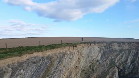 A-man-is-running-on-a-cliff-walk-near-the-edge-and-aerial-footage