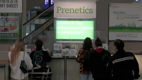 Workers-are-seen-at-the-Covid-19-test-information-counter-at-Chek-Lap-Kok-International-Airport-in-Hong-Kong,-China