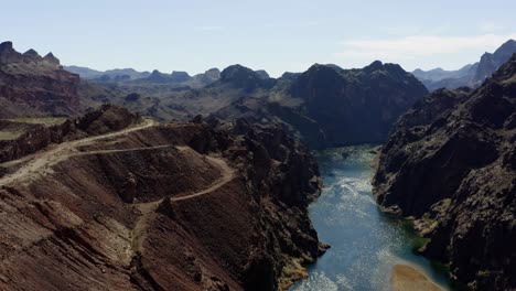 Aerial-drone-view-over-the-Colorado-river,-in-middle-of-mountains,-in-sunny-USA