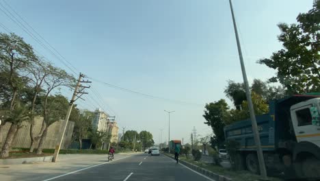 Delhi,-Indien-–-Zeitraffer-Aus-Der-Sicht-Eines-Passagiers-Aus-Einem-Fahrenden-Auto,-Das-Geradeaus-Blickt-Und-Zum-Überqueren-Der-Grenze-Nach-Gurgaon,-Haryana,-Gefahren-Wird