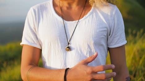 Young-fit-Latin-American-man-wearing-pendant-removes-hand-from-chest,-Close-up-slow-motion-shot