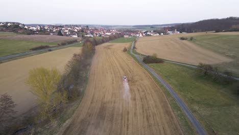 Pequeño-Tractor-Preparando-Un-Campo-Polvoriento-Marrón-Para-La-Primavera-En-Alemania