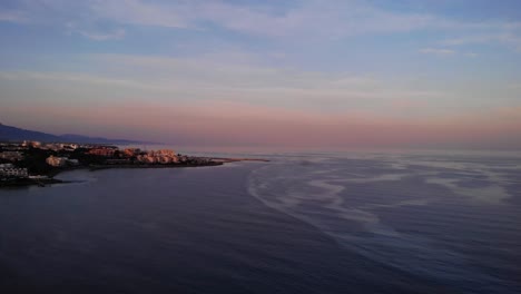 Rosafarbener-Sonnenuntergangshimmel-über-Dem-Ruhigen-Meer-An-Der-Costa-Del-Sol,-Estepona,-Spanien