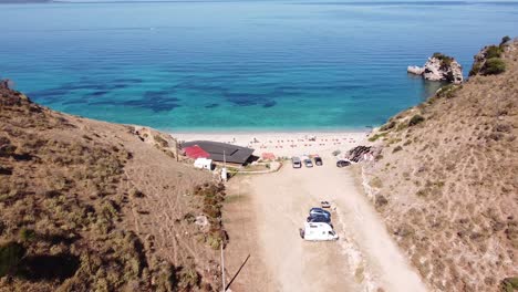 Entrance-to-Mirror-Beach-and-Clear-Blue-Ionian-Sea-in-Ksamil,-Albania---Aerial