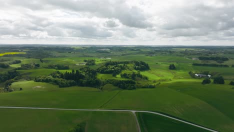 Panoramablick-Auf-Das-Feld-Eines-Bauern,-Es-Gibt-Kleine-Wälder-Auf-Den-Feldern,-Sonnenstrahlen-Dringen-Durch-Die-Wolke-Am-Himmel