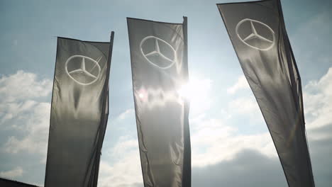 Schwarze-Banner-Mit-Mercedes-Benz-Logo,-Das-Vom-Wind-Gegen-Das-Sonnenlicht-Geweht-Wird
