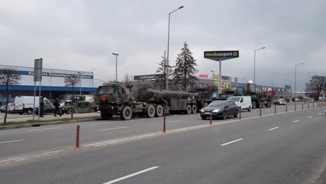 Several-military-HEMTT-equipment-trucks-parked-on-the-road