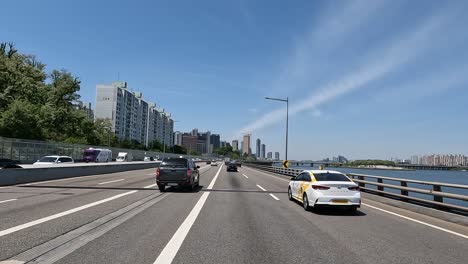 Driving-At-Olympic-dero-Highway-Along-The-High-rise-Apartment-Buildings-And-Han-River-On-A-Sunny-Day-In-Seoul,-South-Korea
