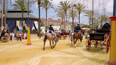 Tres-Personas-Montan-A-Caballo-A-Través-Del-Recinto-Ferial-En-La-Feria-Del-Caballo-De-Jerez,-España