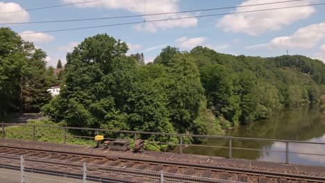 Tren-De-Carga-Rápido-Cruzando-Un-Viejo-Puente-Oxidado-En-Un-Día-Soleado-En-Europa