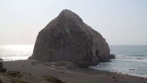 Massiver-Felsen-An-Einem-Einsamen-Strand-Im-Süden-Chiles-Und-Menschen-Am-Strand