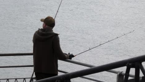 Hombre-Con-Caña-De-Pescar-En-El-Embarcadero-Del-Muelle-De-Llandudno-Preparándose-Y-Esperando-Con-Anticipación