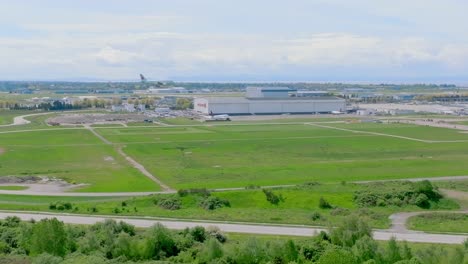 Weitläufige-Landschaft-Des-Internationalen-Flughafens-Yvr-Vancouver-Mit-Einem-Gefleckten-Flugzeug,-Das-Kurz-Vor-Der-Landung-In-Richmond,-Kanada,-Steht