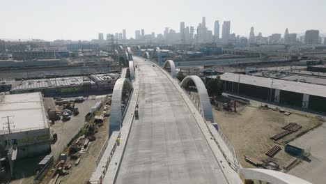Drone-Flying-Over-Newly-Reconstructed-Sixth-Street-Viaduct-Bridge-in-Downtown-Los-Angeles,-Skyline-on-Horizon