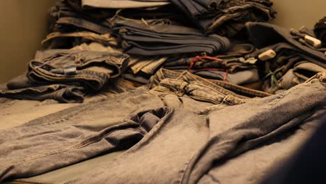 Trabajador-Revisando-Jeans-De-Mezclilla-De-Pila-Bajo-Luz-En-Fábrica-En-Pakistán