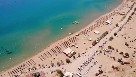Aerial-View-Of-Tsambika-Beach,-Water-Park-And-Calm-Blue-Sea-At-Sumer-In-Greece