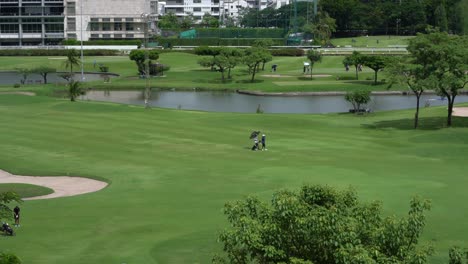 Caddy-Trägt-Die-Golftasche-Für-Den-Golfer-Auf-Dem-Golfplatz-Im-Zentrum-Von-Bangkok