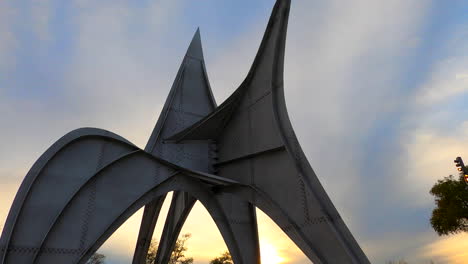 Sonnenuntergangsneigungsansicht-Von-Alexander-Calder-Metallisches-Skulpturendenkmal-Im-Freien-Im-Parc-Jean-Drapeau-Montreal,-Modernes-öffentliches-Künstlerisches-Meisterwerk,-Kreative-überlappende-Stahlbögen,-Stadtbild-Von-Montreal
