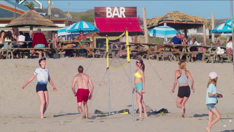 Local-Friends-Enjoying-The-Summer-Playing-Beach-Volleyball-on-Perranporth-Beach-Sands,-Cornwall,-UK---Slow-Motion