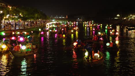 Farbenfrohe,-Romantische,-Verträumte-Atmosphäre-Beim-Laternenfest-In-Hoi-An,-Vietnam,-Panoramablick-Auf-Beleuchtete-Bootskanus,-Die-Auf-Dem-Kanalfluss-Segeln,-Touristen-An-Bord,-Tourismusziel