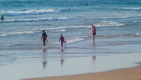 Rompiendo-Las-Olas-De-La-Playa-De-Perranporth-Con-Gente-Durante-El-Verano-En-Cornwall,-Inglaterra,-Reino-Unido