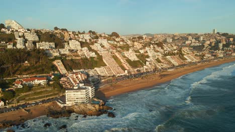 Aerial-view-flying-towards-Reñaca-affluent-cityscape-resort-waterfront-and-golden-beach-coastline