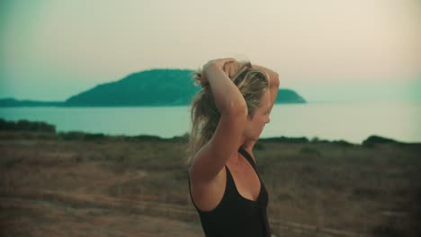Greek-goddess-woman-wearing-black-dress-enjoying-summer-sunset-at-evening-by-the-Greek-sea-and-islands