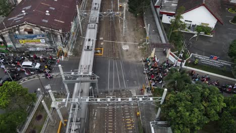 aerial-view,-The-train-passing-through-a-busy-intersection,-the-train-will-stop-at-Lempuyangan-Yogyakarta-station