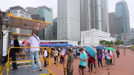 People-queue-in-line-to-receive-PCR-tests-for-coronavirus-from-a-Community-Testing-Centre-truck-to-tackle-the-spread-of-the-virus-and-a-pandemic-wave-near-Hong-Kong's-financial-district