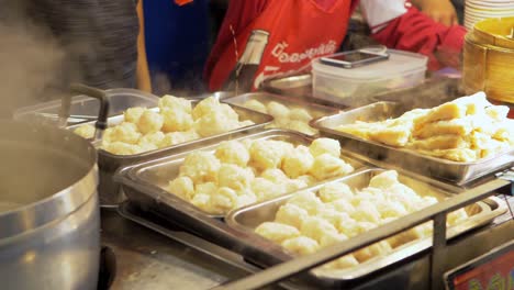 Chef-stuffing-Chinese-dumplings-in-Yaowarat-Road-Chinatown,-popular-travel-destination-Bangkok,-Thailand