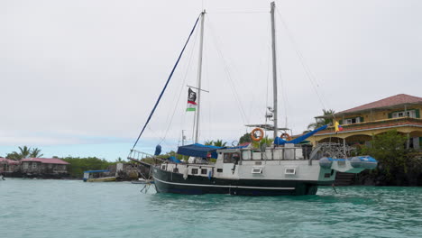 Pasando-Velero-Amarrado-Frente-A-La-Costa-Con-Vista-Del-Restaurante-Isla-Grill-En-Santa-Cruz-En-Las-Galápagos