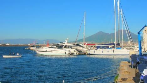 Aufnahme-Von-Booten,-Die-In-Einem-Seehafen-Anlegen,-Mit-Blick-Auf-Den-Vesuv-Am-Horizont-In-Neapel,-Italien,-Tagsüber