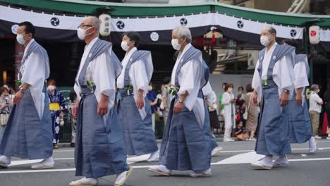 Hombres-Japoneses-En-Trajes-Tradicionales-Caminan-Por-Las-Calles-De-Kyoto,-Marcha-De-Gion-Matsuri