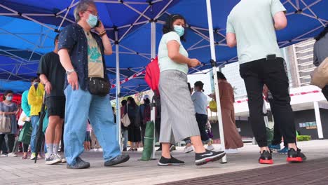 Menschen-Stehen-Schlange,-Um-PCR-Tests-Auf-Coronavirus-Von-Einem-Lastwagen-Des-Gemeindetestzentrums-Zu-Erhalten,-Um-Die-Ausbreitung-Des-Virus-Und-Eine-Pandemiewelle-In-Der-Nähe-Des-Finanzviertels-Von-Hongkong-Zu-Bekämpfen