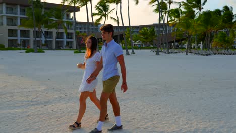 Young-adults-walk-on-white-sand-beach