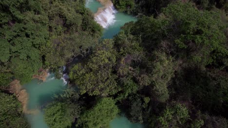 Blue-river-in-the-middle-of-the-jungle-in-Chiapas,-Mexico,-drone-shot-from-zenith-then-tilting-up