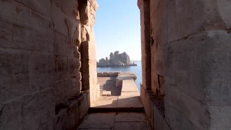 Blick-Auf-Felsen-Im-Nil-Durch-Zwei-Wände-Des-Philae-Tempels-In-Assuan,-Ägypten