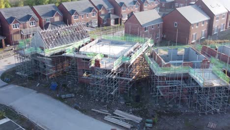 Aerial-view-above-suburban-townhouse-framework-on-development-construction-site-during-economic-recession