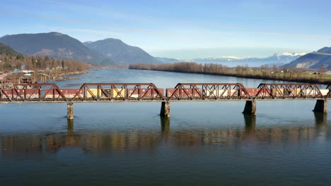 Aerial-View-Of-Freight-Train-Crossing-On-Mission-Railway-Bridge-In-Mission,-BC,-Canada---drone-shot