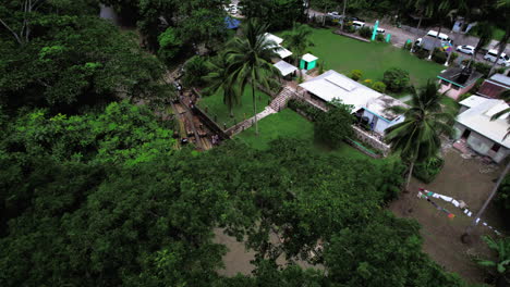 Luftaufnahme-Eines-Kais-Neben-Regenwald-Und-Braunem-Fluss-Mit-Bambusflößen-In-Jamaika