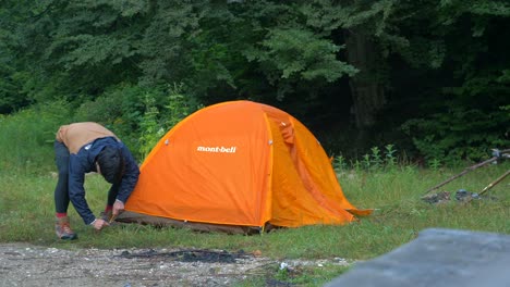 Hombre-Desmontando-Carpa-En-Un-Camping-4k